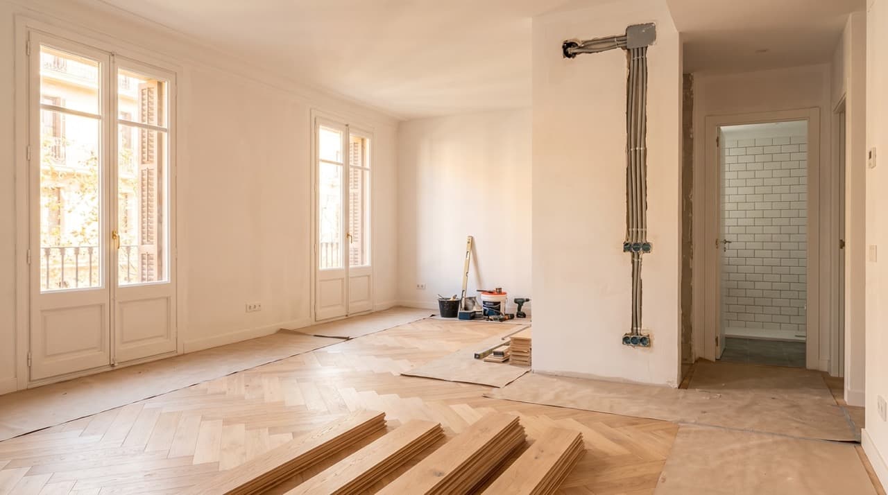 Piso en Barcelona durante una reforma integral con suelos nuevos instalaciones renovadas y paredes preparadas para pintar